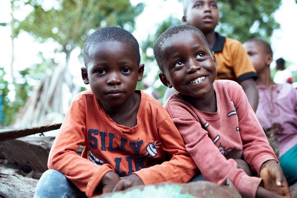 A group of smiling children enjoying playtime outdoors at a park.