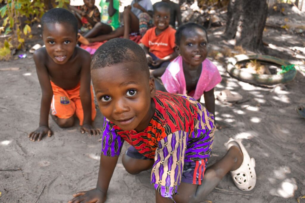 A joyful group of African children playing together outside in Monrovia, Liberia, on a sunny day.