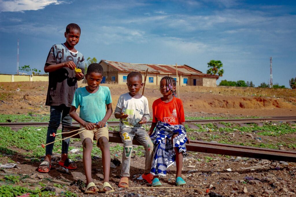 Group of happy children playing near railway tracks in Kaduna, Nigeria.