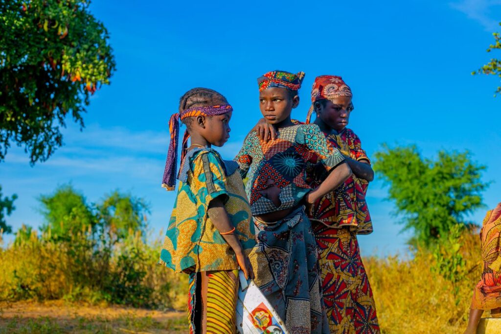 A vibrant outdoor scene of African children in traditional attire, celebrating cultural heritage.